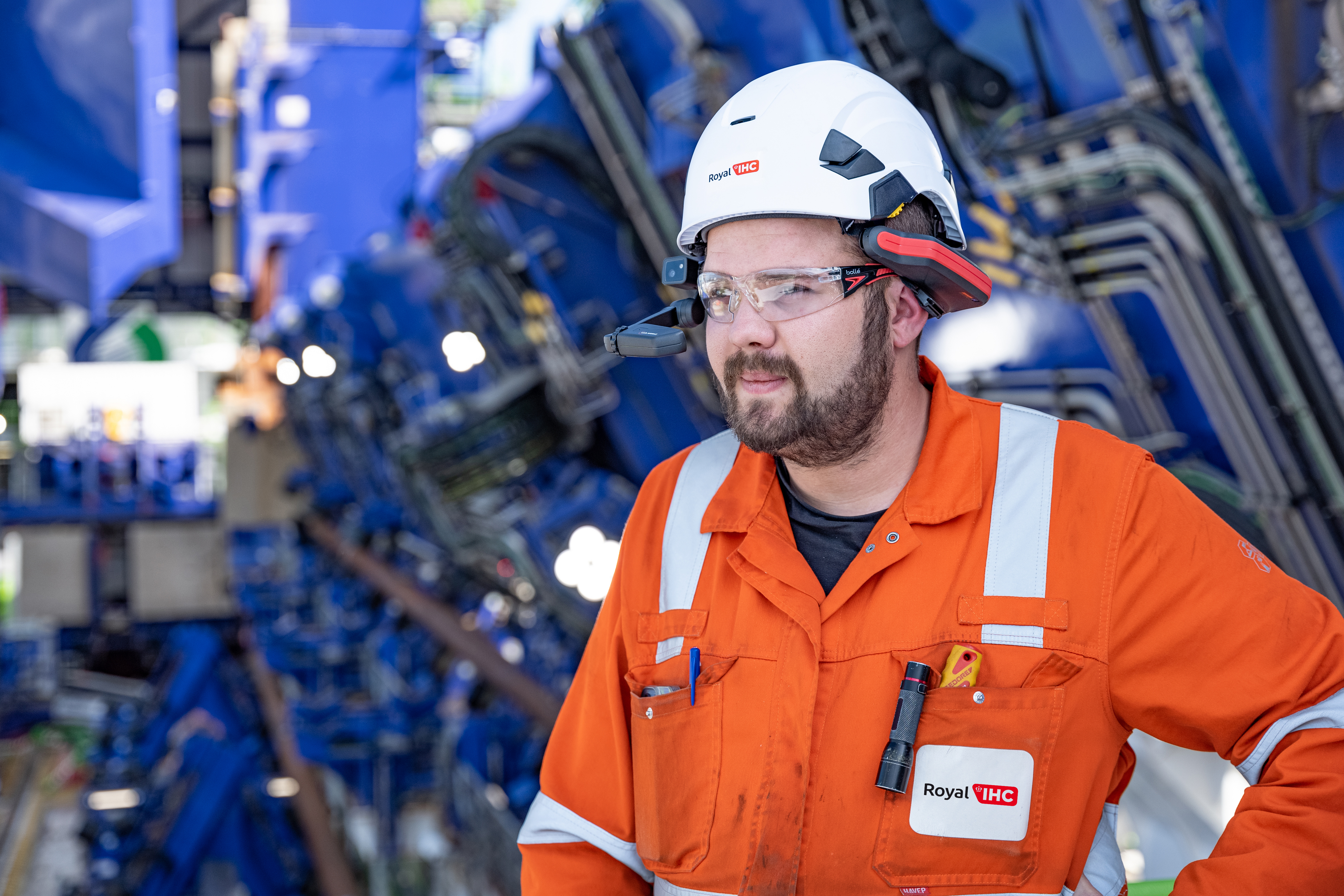 guy in orange overalls, with hardhat and smart glasses